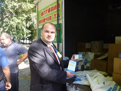 На фото кандидат В. Гладчук демонстрирует пакеты с чаем с фамилией Пилипишин